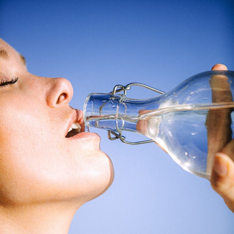 Woman Drinking Water From Glass Bottle